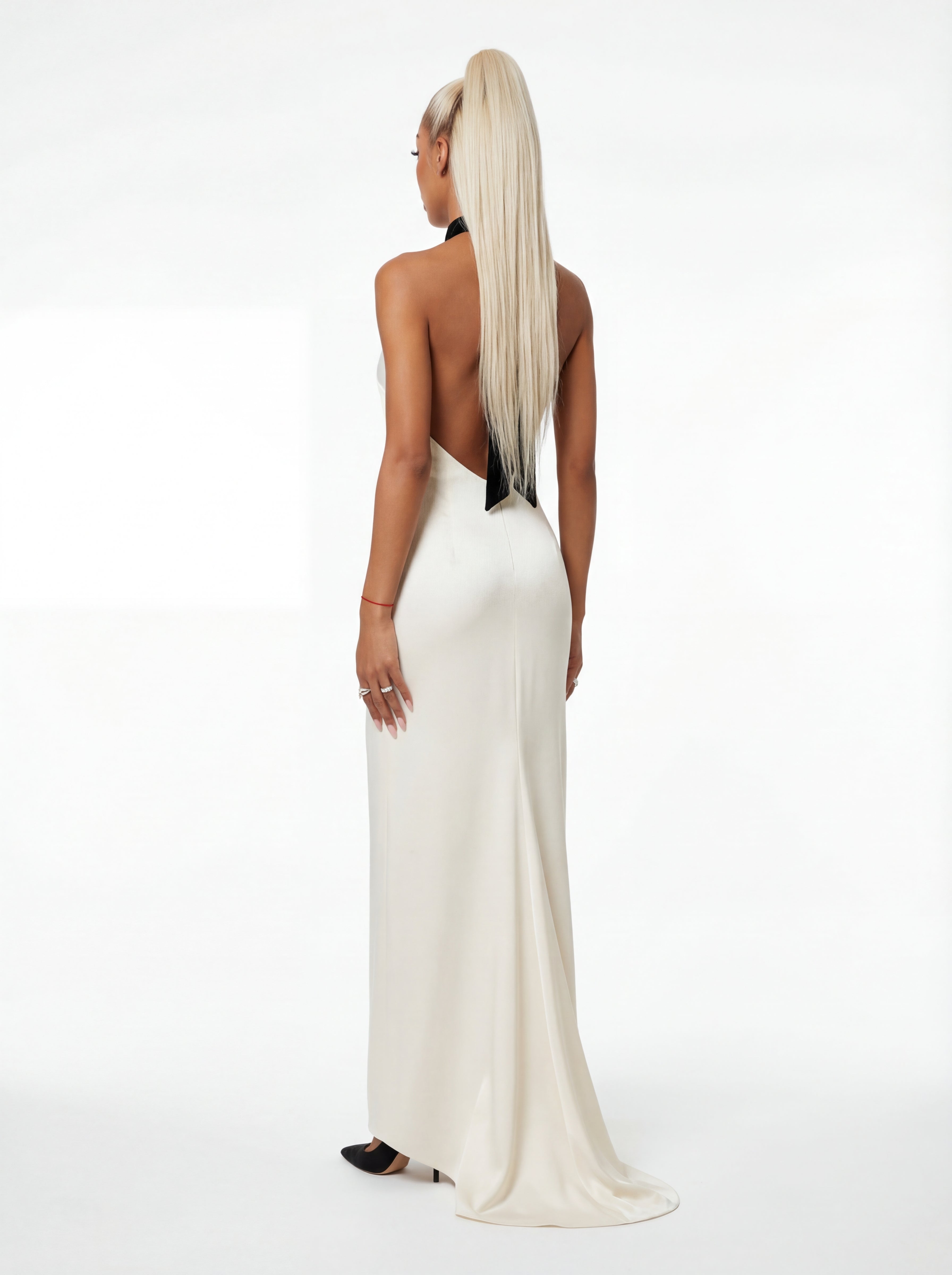 Woman wearing a white evening gown with a black underdress on a white background