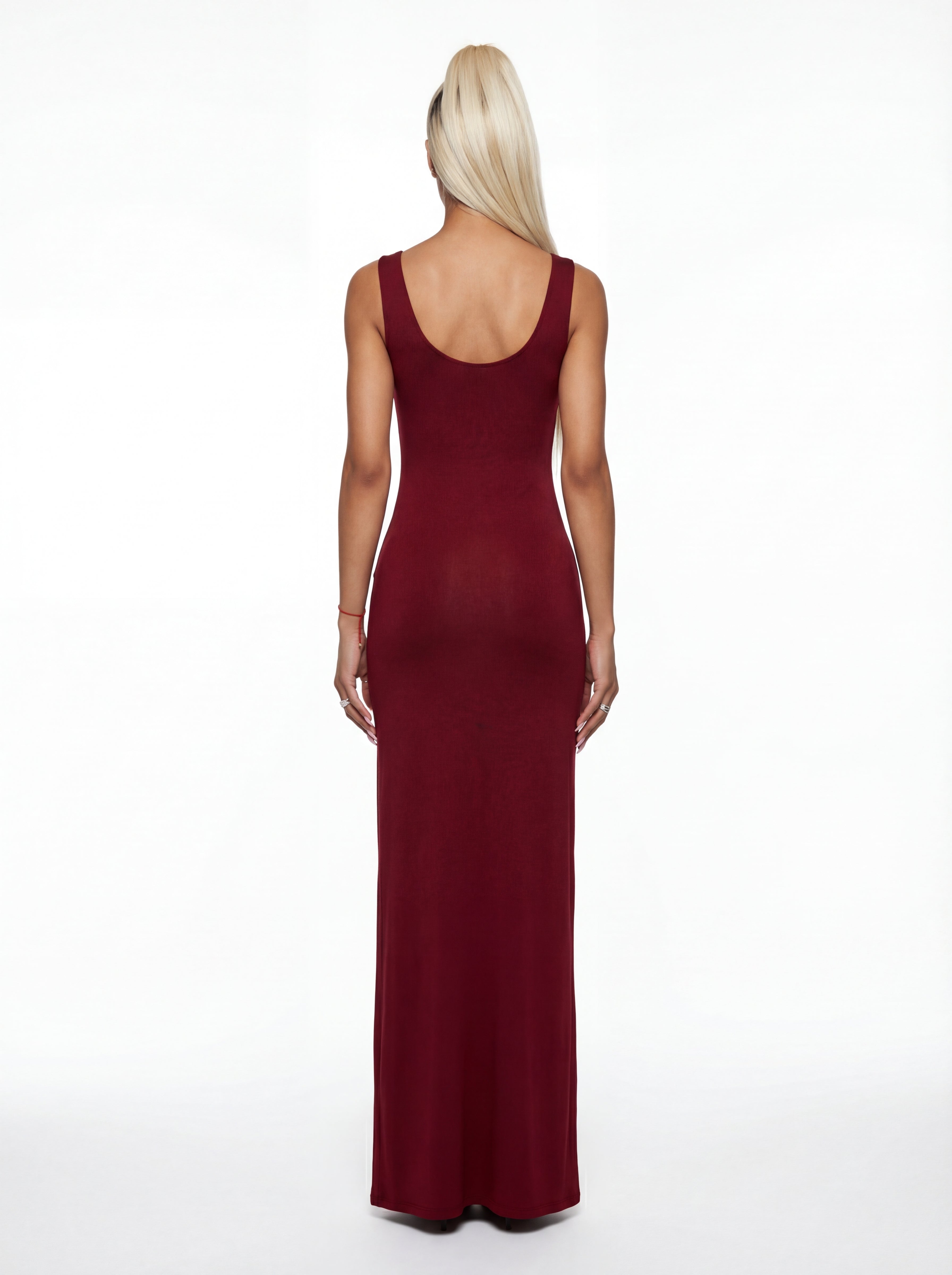Woman wearing a burgundy sleeveless gown on a white background