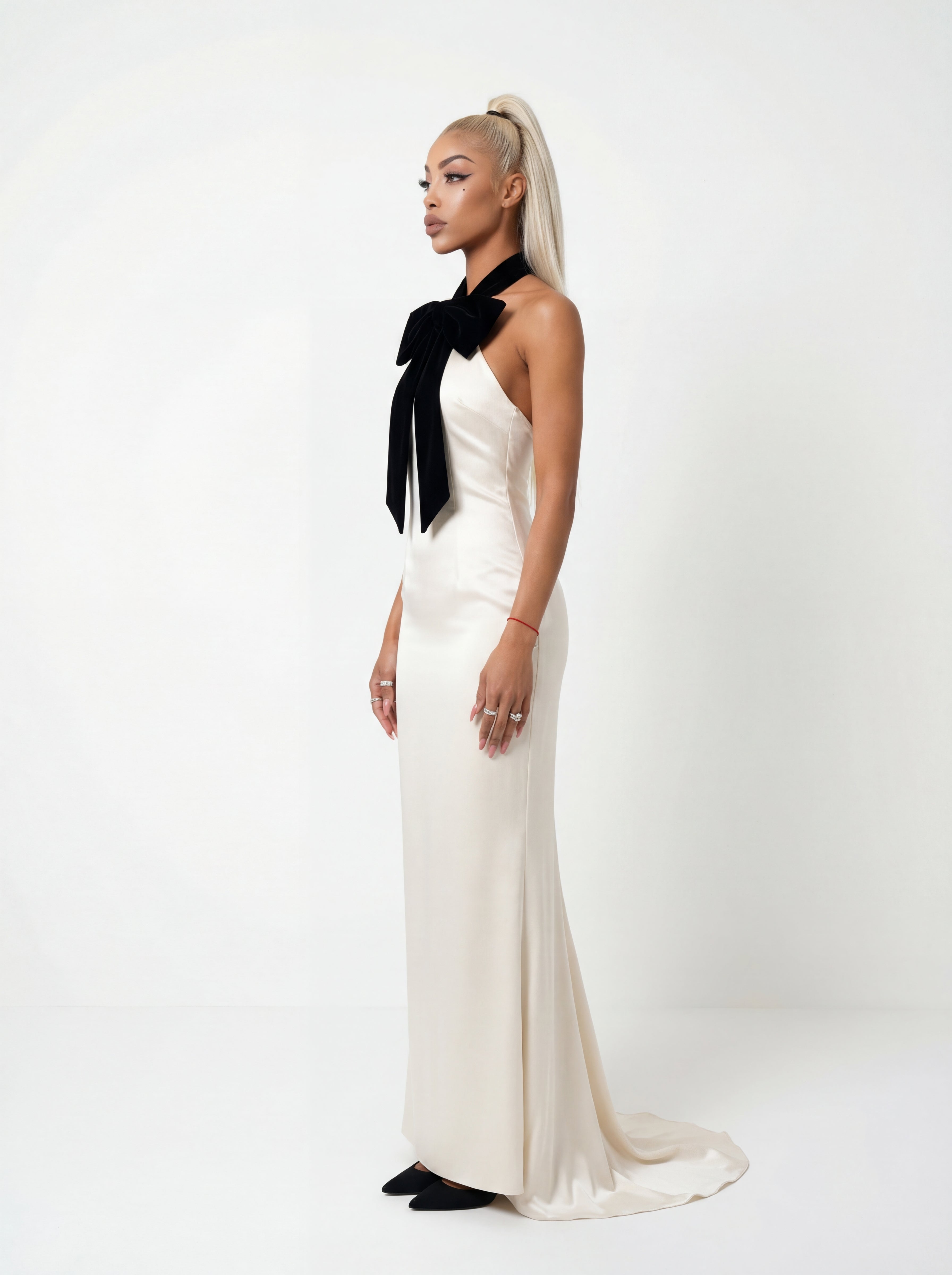 Woman wearing a white dress with a black bow tie on a white background